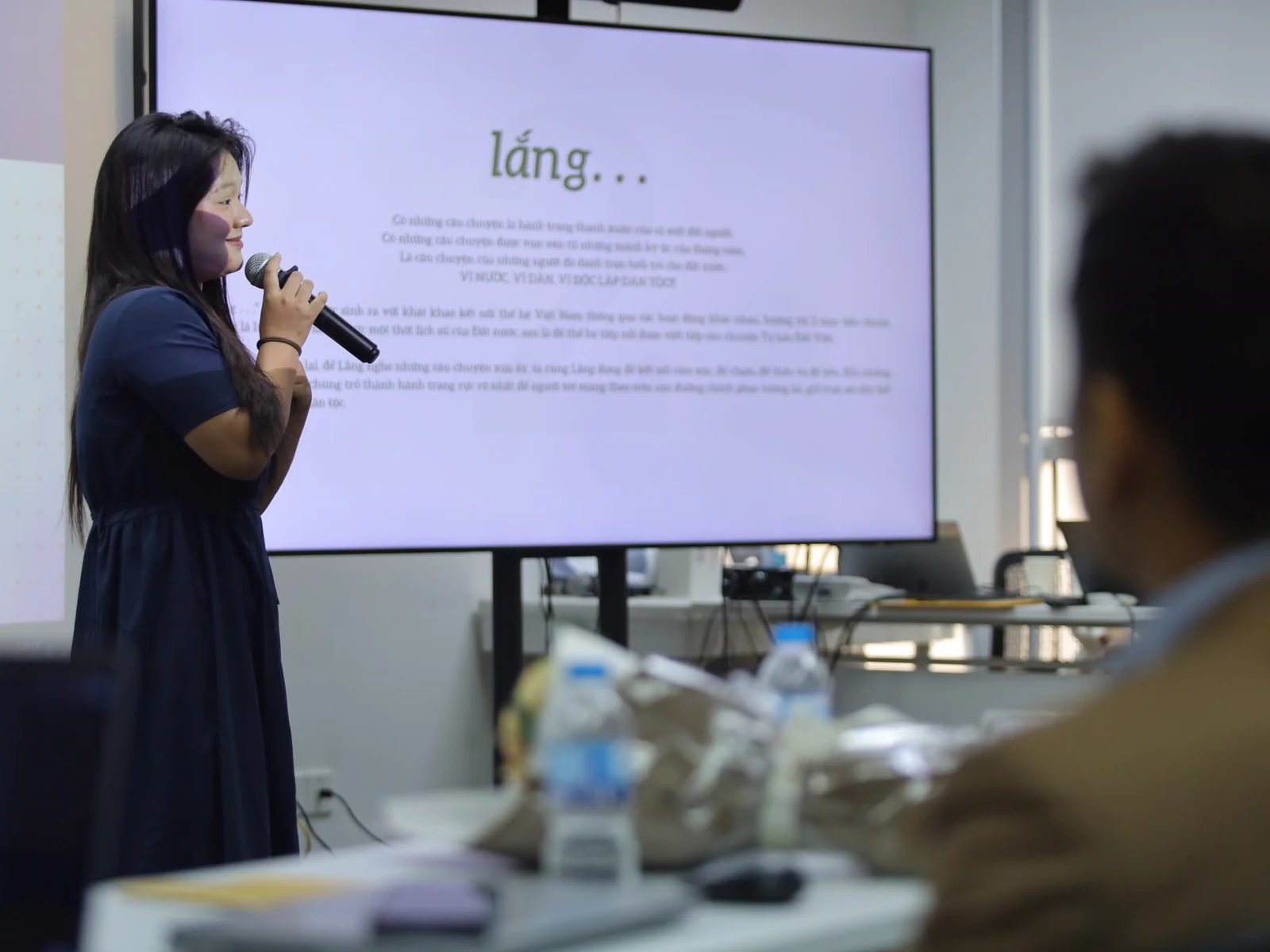 A young woman presenting the lắng project to an audience.