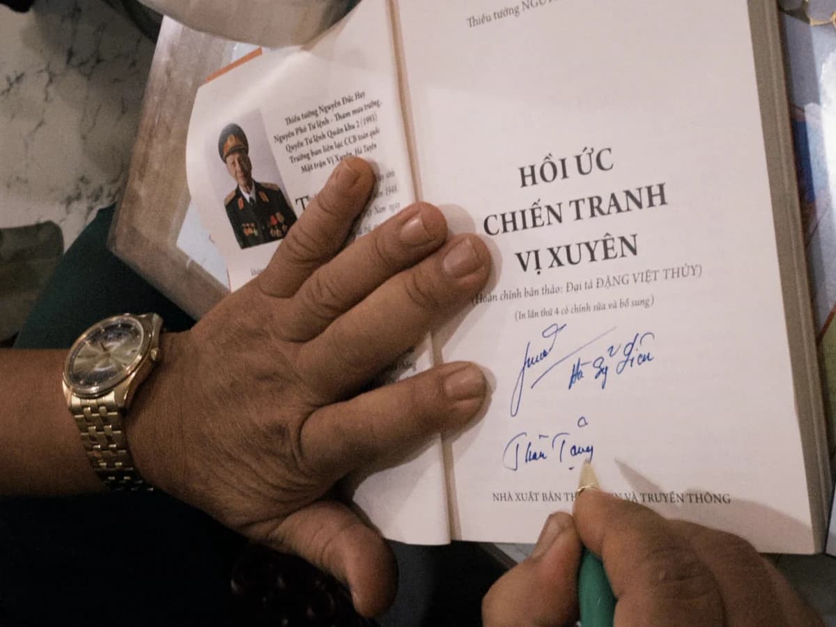 A war memoir opened to a signed dedication page.