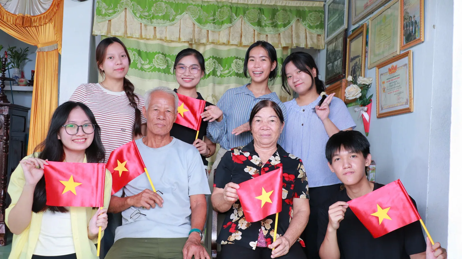 Đoàn lắng chụp cùng hai bác, cả nhóm cầm cờ Tổ quốc.